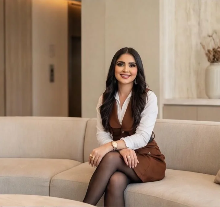 Jeinny García sentada en un sofá crema en un espacio minimalista
